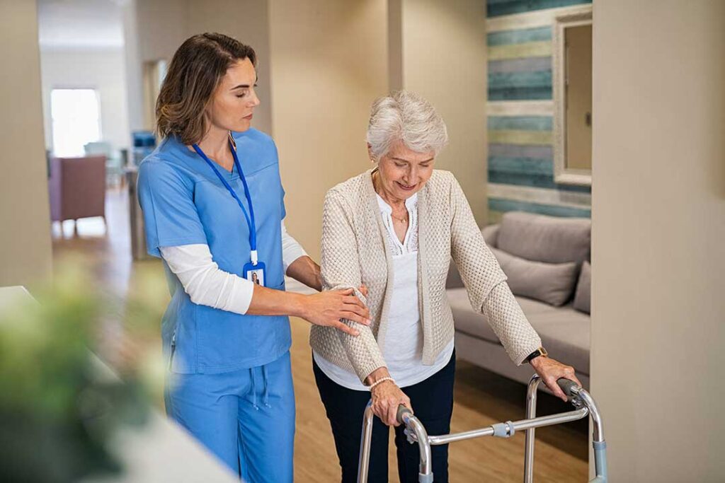 An elderly resident and a family member talking with an assisted living staff member in a comfortable room.